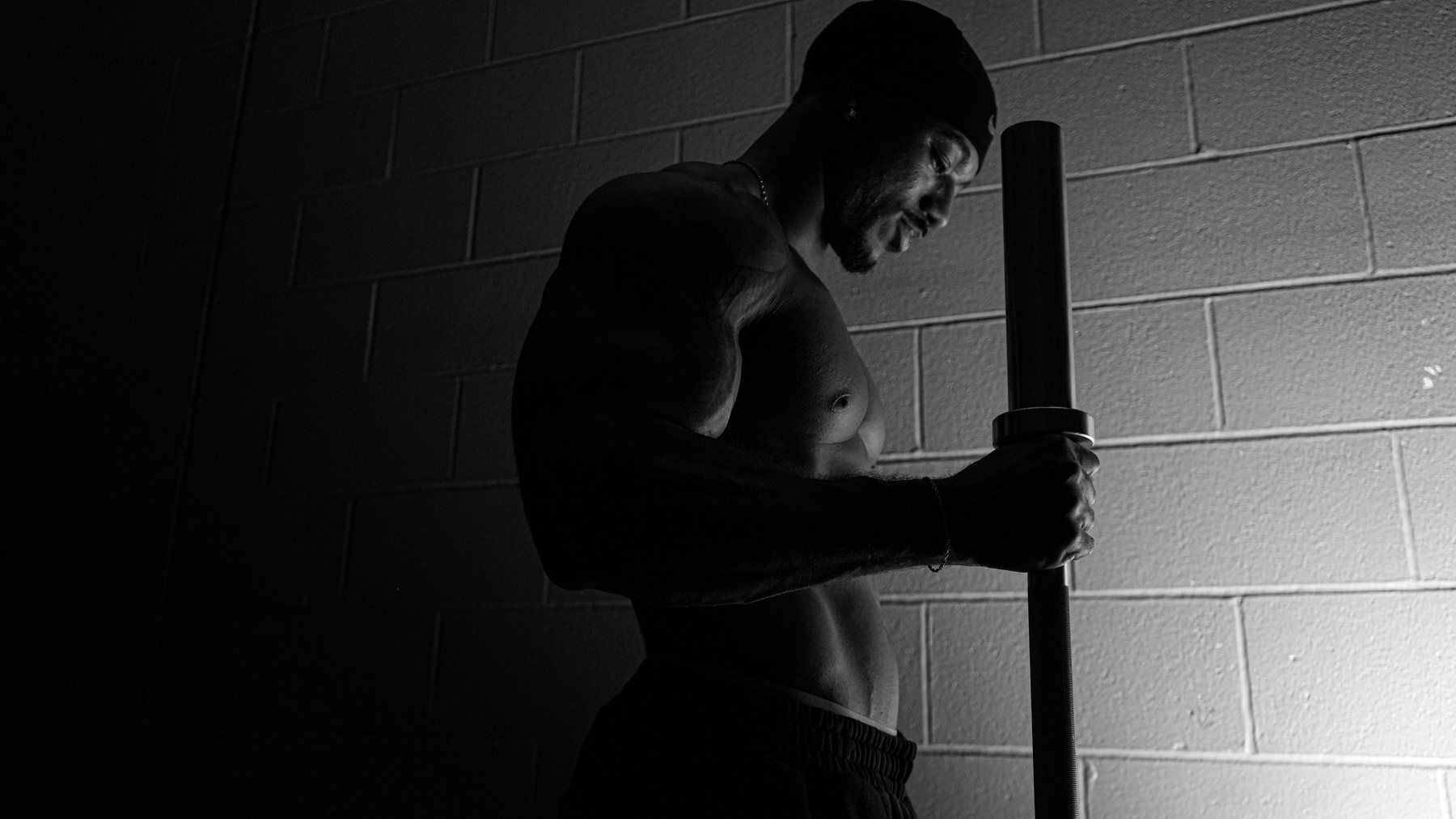 Edward Banks holding a barbell upright, black and white